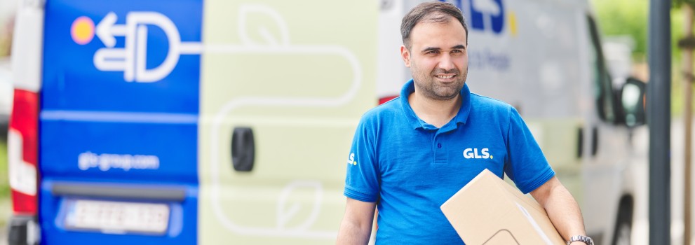 Chauffeur qui tient un colis devant sa camionnette électrique